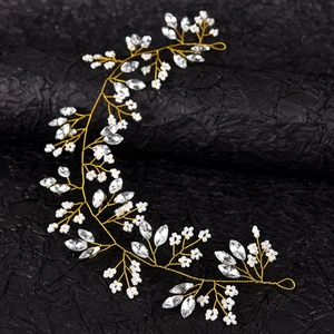 Detailed close-up of handmade bridal hair vine with white flowers and sparkling rhinestones