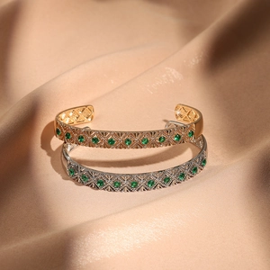 Detail von Vintage-Manschettenarmbändern in Gold und Silber mit grünen Edelsteinen