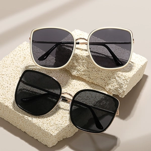 Fashionable oversized sunglasses in black and beige frames on textured stone display