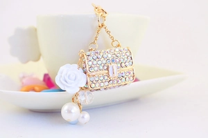 Detail of crystal camellia handbag keychain with white rose and faux pearl accents