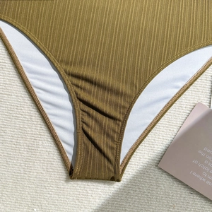 Gros plan du tissu de maillot de bain côtelé kaki avec doublure blanche et coutures