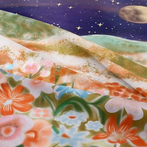 Macro detail of moon phase and floral tapestry fabric showing soft texture and drape