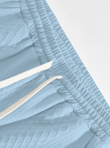 Detailed macro view of light blue waffle textured leisure pants with elastic drawstring waist
