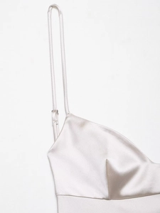 Detail of champagne satin dress showing adjustable shoulder straps and silky texture