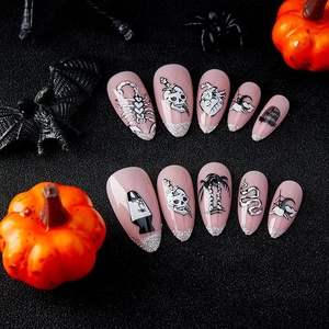 Faux ongles amande roses avec motifs crâne et cœur pour Halloween sur fond noir