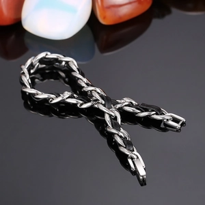 Bracelet minimaliste en chaîne NK argentée et cuir tressé noir sur une surface réfléchissante