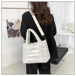 Quilted puffer tote bag in pearl white shown worn over the shoulder with wide fabric strap