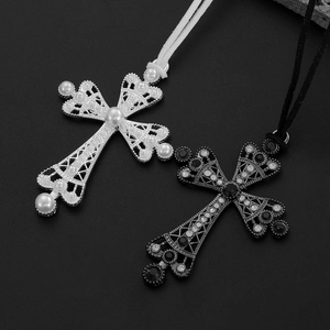 Détails de pendentifs croix gothiques avec perles et pierres noires sur fond sombre
