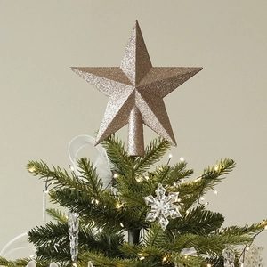 Sparkling champagne gold star tree topper with glitter finish on a Christmas tree