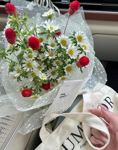 Detail of floral bouquet with white mesh snow point wrap and french style card
