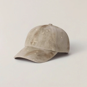 Detail of vintage washed khaki baseball cap featuring fine floral embroidery and paint splatters