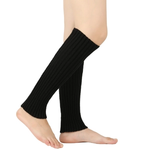 Detail of black knitted leg warmers showing vertical ribbed texture and elastic knit fabric