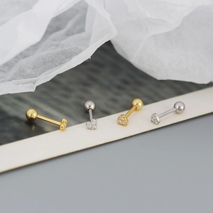 Macro shot of gold and silver S925 heart stud earrings with sparkling zircon inlay