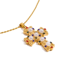Collana a croce barocca dorata con perle e strass colorati su una sottile catena a sfere