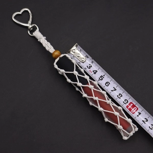 Detail view of handmade macrame lipstick holder with heart clasp and wooden bead