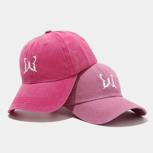 Washed cotton baseball caps in pink and rose with white butterfly embroidery and curved brim