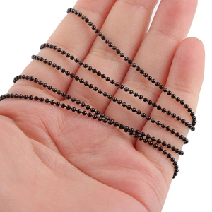 Macro shot of 1.5mm black stainless steel ball chain wrapped around a hand for DIY jewelry
