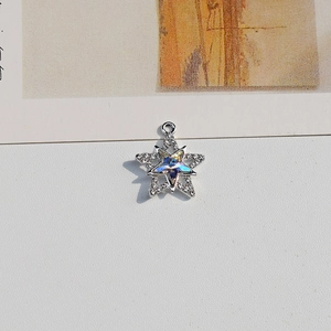 Macro detail of star-shaped pendant with blue aurora crystal and micro-pave crystals