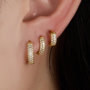 Three rows of pave-set diamond gold hoop earrings for a luxury ear stack look