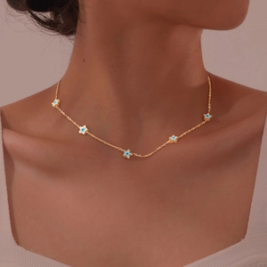 Detailed close-up of a gold star necklace with evil eye pendants worn by a model