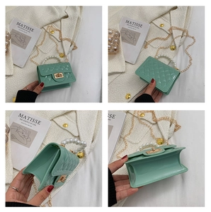 Detail view of mint green silicone jelly bag with pearl handle and quilted texture