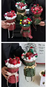 Close-up of Christmas apple bouquet with plush Santa decor and festive red ribbons