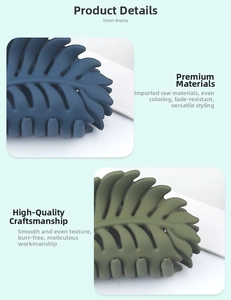 Detail view of leaf-shaped hair claws in matte navy blue and olive green finish