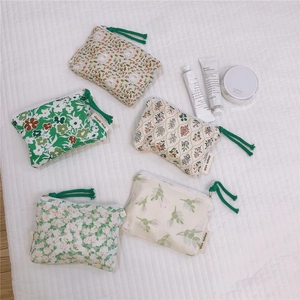 Detailed view of five floral cotton mini pouches with green rope zipper pullers