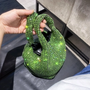 Detailed view of green rhinestone bucket bag sparkling under natural sunlight