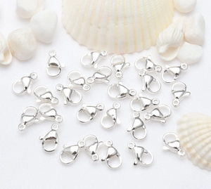Polished silver lobster clasps for DIY jewelry making on white textured background