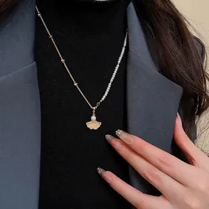 Elegant gold maple leaf pendant necklace with pearls and sparkling zircon stones
