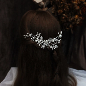 Detail of silver bridal hair comb set with sparkling rhinestones and delicate pearls