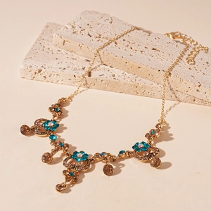 Detailed close-up of floral chain necklace with blue crystals and amber pendants