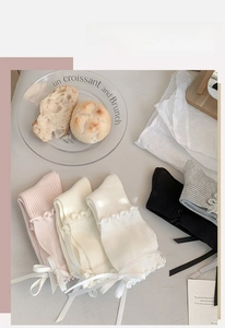 Detailed view of ruffle cuff socks with silk bows in pastel and neutral colors