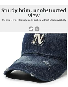 Detailed view of denim baseball cap featuring distressed fabric and white embroidered N letter