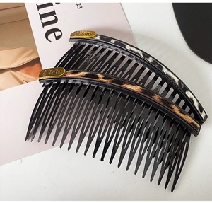 Detailed view of two leopard and zebra print hair combs with Baby lettering