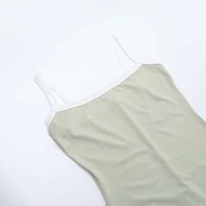 Close-up of bean green knit dress featuring white contrast straps and square neckline
