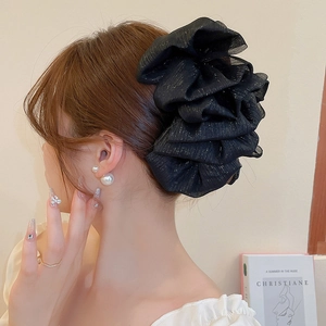 Détail d'un chouchou noir scintillant surdimensionné porté par le mannequin