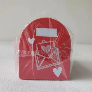 Macro detail of red tin mailbox gift box with white hearts and protective film