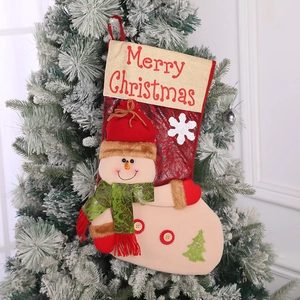 Detail of red snowman Christmas stocking with Merry Christmas embroidery on a snowy tree