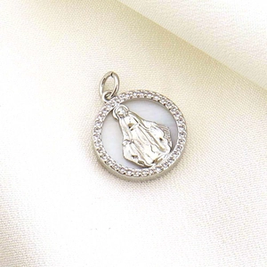 Detailed shot of Virgin Mary pendant with silver relief and shimmering crystal border