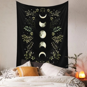 Detail of bohemian black tapestry with moon phases and yellow leaves on white wall