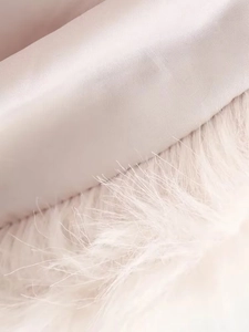 Macro detail of soft pink velvet fabric texture with fluffy faux feather trimmings