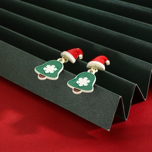 Festive Christmas hat and snowflake bell earrings on a green folding fan background