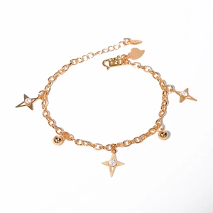 Detailed shot of golden thin chain bracelet with zircon stars and heart charm decoration