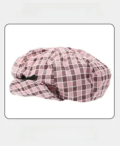 Pink and brown checkered newsboy cap detail with adjustable strap and sweatband lining
