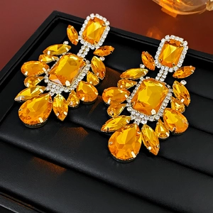 Macro shot of chandelier earrings with amber stones and sparkling white rhinestones