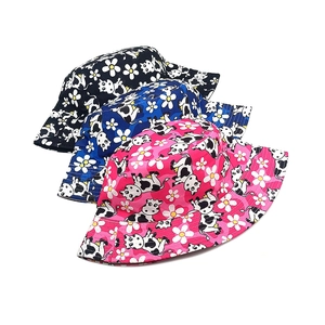 Détail de chapeaux bob pour bébés avec motifs mignons de vaches et marguerites multicolores