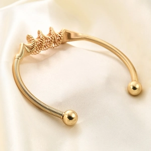 Macro view of 4mm golden twisted spiral bracelet on elegant silk background