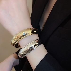 Détails des bracelets en métal doré et argenté avec design à texture fluide de lave